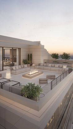 an outdoor fire pit on the roof of a modern home at sunset or dawn with patio furniture and potted plants