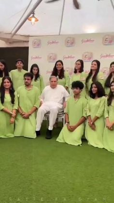 a group of people in green dresses posing for a photo