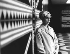 black and white photograph of a woman leaning against a wall