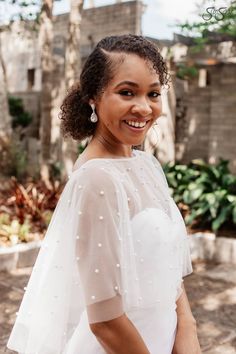 a woman in a white dress smiling at the camera