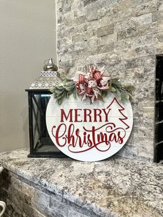 a merry christmas sign sitting on top of a fireplace mantel next to a brick wall