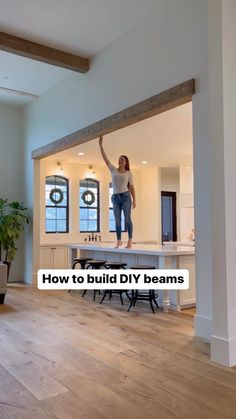 a woman standing on top of a kitchen counter in front of an open doorway with the words how to build diy beams