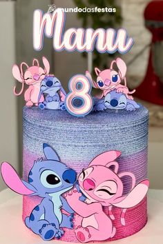 the birthday cake is decorated with pink and blue frosting, as well as cartoon characters