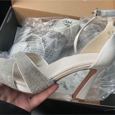 someone is holding their wedding shoes in a box