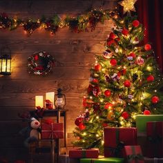 a decorated christmas tree in front of a wooden wall with lights and presents under it