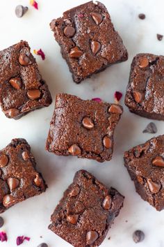 chocolate brownies are arranged on a white surface