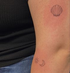 a woman with a tattoo on her arm has a shell and the moon behind it