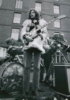 an old black and white photo of a man holding a guitar in front of other musicians