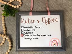 a sign that says kate's office hangs on the wall next to a bead necklace