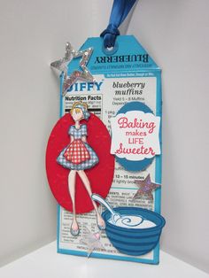 a paper doll hanging from a blue ribbon