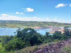 a large dam on the side of a river surrounded by lush green trees and rocks