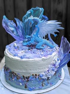 a blue and white cake with a dragon on top