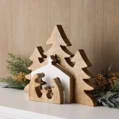 a wooden christmas tree with a house shaped like a snowflake next to it