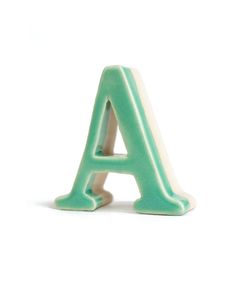 a pink and white ceramic letter sitting on top of a table