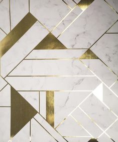 a white marble wall with gold lines and triangles