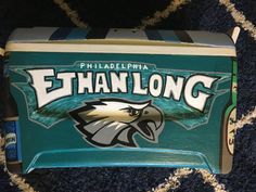 a philadelphia eagles lunch box sitting on top of a blue carpeted floor next to a rug