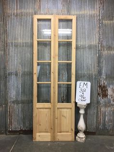 a tall wooden cabinet sitting next to a metal wall