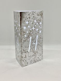 a silver box with white stars and numbers on the front is sitting on a table