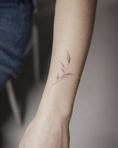 a woman's arm with a small tattoo on the left side of her wrist