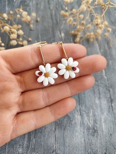 small white flower earrings with red stones on them