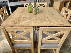 a wooden table with chairs and bottles on it