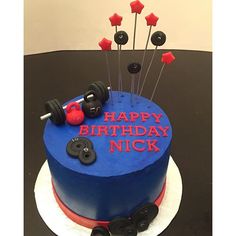 a blue birthday cake with red and black decorations