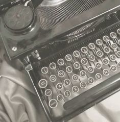 an old fashioned typewriter sitting on top of a bed