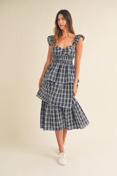 This navy midi dress has a sweetheart neckline and playful ruffle sleeves. The tiered ruffle bottom adds a touch of fun and femininity. Take your fashion game to the next level with the Lara Plaid Sweetheart Ruffled Midi Dress. Brunch Midi Dress With Ruffled Skirt And Straps, Flirty Tiered Midi Dress For Brunch, Flirty Tiered Midi Dress With Ruffled Skirt, Midi-length Tiered Dress With Ruffled Skirt For Brunch, Chic Navy Midi Dress With Ruffles, Flirty Ruffled Midi Dress For Dress Down, Flirty Ruffled Midi Dress For Casual Wear, Flirty Midi Ruffle Dress With Ruffle Hem, Flirty Midi Dress With Ruffles