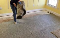 a man is rolling up the carpet in his living room