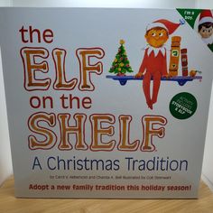 an advertisement for the elf on the shelf christmas tradition is displayed in front of a wooden table