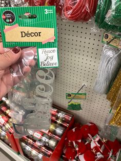 a person holding up a plastic bottle with christmas decorations on it in a store aisle