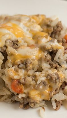 a white plate topped with rice covered in cheese and meat mixtures on top of it