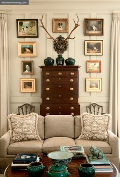 a living room filled with lots of furniture and pictures on the wall above it's coffee table