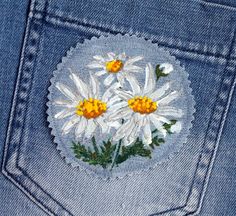 a pair of jeans with daisies embroidered on the back of it's pocket