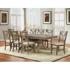 a dining room table with six chairs and a rug in front of the window,