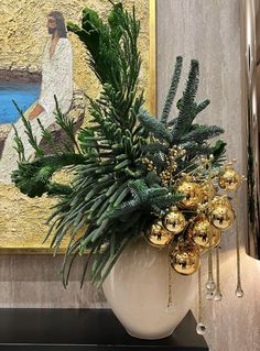 a potted plant sitting on top of a table next to a wall with a painting behind it