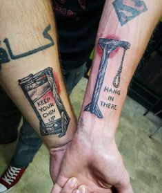 two people holding hands with tattoos on their arms that read keep your cup in there