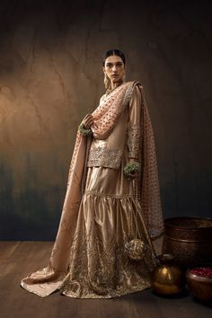 A Tissue short shirt in Buff with full sleeves, paired with a matching Two-legged gharara. The set includes an Apricot Organza dupatta with work on all four sides and an additional Shawl in Shimmer silk. Discover our Indian wedding collection, featuring bespoke outfits, gowns, and ghararas that embody the essence of tradition and modernity for your special day.In the spotlight is a captivating ensemble featuring a Buff Tissue short shirt with full sleeves, flawlessly paired with a matching Buff Chunni Ceremony, Jaggo Night, Sufi Night, Pakistani Bridal Dresses Online, Qabool Hai, Bridal Gharara, Classy Couture, Gharara Designs, Night Fits