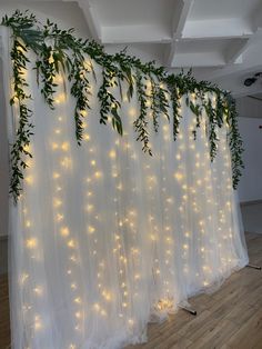 the curtain is decorated with lights and greenery