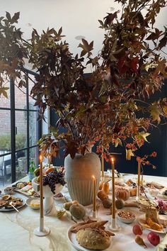 a table is set with plates and candles for an elegant fall dinner or brunch