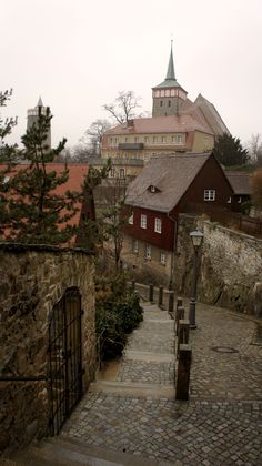 an old stone building with a steeple in the background and stairs leading up to it