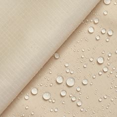 "The nylon ripstop fabric is a durable and synthetic fabric that is perfect for all types of indoor and outdoor use. This fabric is 70 denier, 100% nylon, and 62/23\" inches wide. It is a light-weight interwoven fabric, using special synthetic fibers to create a square like pattern. The special fibers used are placed within the weave at specific points, allowing for the fabric to have superior quality and hold against all types of wear and tear. This fabric in particular is specially coated with PU (polyurethane). PU coating allows for the ripstop to be waterproof by using a seam sealing process (the process of covering the stitch holes and seams in a fabric to prevent any water leakage), withstanding all types of water exposures. Compared to many other ripstop fabrics within the industry Waterproof Fabrics, Folding Fabric, Types Of Water, Frilly Socks, Material Research, Waterproof Tent, Ripstop Fabric, Stain Resistant Fabric, Water Repellent Fabric