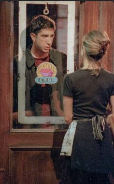 a man and woman standing in front of a mirror looking at each other's faces