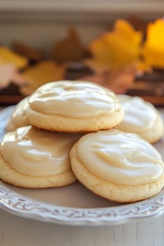 three cookies with frosting on a white plate