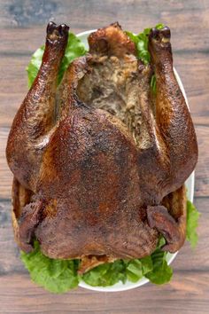 a whole chicken sitting on top of lettuce