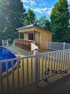 a deck with a swimming pool next to it and a small wooden house on the other side