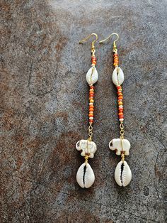 Long Cowrie Shell Beaded Orange Earrings, Elephant, Wire Wrap, Bohemian Jewelry,  Dangle Earrings Orange multicolor beads, Agate elephant beads, Cowrie shells, 5" length, light weight. Still shopping? Wonderful. www.etsy.com Gold Earrings With Latkans For The Beach, Gold Latkans Earrings For Beach, Gold Latkan Earrings For The Beach, Beach Earrings With Latkans, Bohemian Beaded Earrings With Latkans For Beach, Bohemian Beaded Latkans Earrings For Beach, Bohemian Latkans Earrings For Beach, Bohemian Beaded Latkan Earrings For Beach, Beach Earrings With Dangling Beads