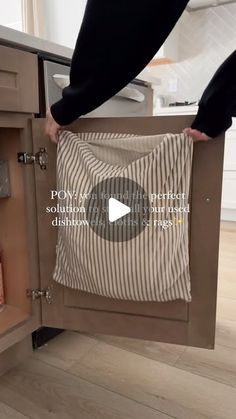 someone is opening the cabinet in their kitchen to show how it looks like they are holding something