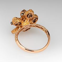 This unique Neda Behnam Couture ring is centered with petal shaped settings accented with rough diamonds and six (6), bezel set, round brilliant cut diamonds. The shoulders of the ring are each accented with twenty-two (22), bead set, round brilliant cut diamonds. The ring measures 20.9mm at the top, rises 11.4mm above the finger, tapering to 2.8mm wide and 1.3mm thick at the base of the shank. Signed Neda Couture. "750 18K y' F454 D037" is stamped on the inside shank. This ring is currently a s Luxury Diamond Cluster Ring With Bezel Setting, Unique Formal Diamond Ring With Single Cut Diamonds, Unique Rose Cut Diamond Ring For Formal Occasions, Unique Formal Rose Cut Diamond Ring, Unique Cluster Ring With Rose Cut Diamonds, Unique Rose Cut Diamond Ring, Unique Bezel Set Diamond Ring, Petal Ring, Bead Set