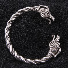 The Viking arm ring is a stunning example of the craftsmanship and attention to detail that was valued in Viking culture. With their intricate designs and powerful symbolism, these bracelets are a true expression of the strength, courage, and resilience of the Viking warriors who wore them, making them a must-have accessory for any collector. Product details: Material: 925 Sterling Silver Weight: 60g One size fits all Free wooden gift box and jewelry bag included Free worldwide shipping Arm Rings, Viking Arm Rings, Dragon Heads, Viking Warriors, Arm Ring, Viking Culture, Dragon Bracelet, Viking Bracelet, Silver Dragon